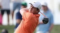 Robert MacIntyre, wearing an orange polo and white cap, holds his finish on a drive