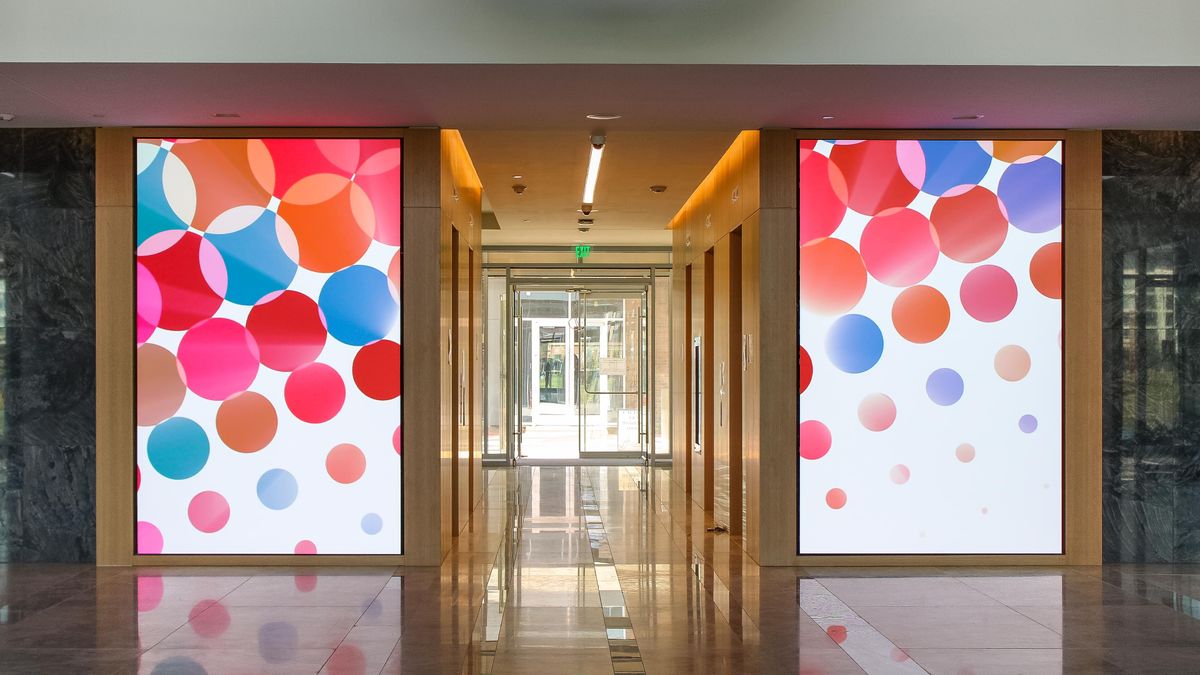 A vibrant and colorful polka dot digital display highlights the entryway in a Dallas property.