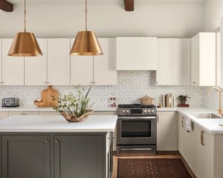 modern kitchen with white cabinets, gray island and copper pendant lights