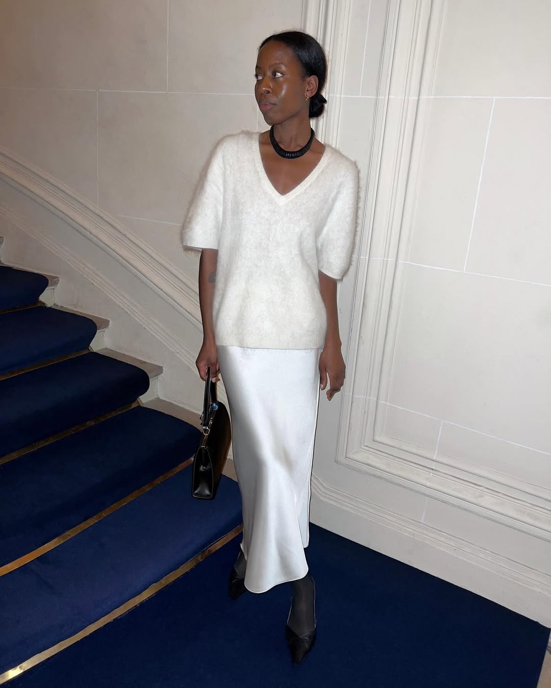 Image of Sylvie Mus posing for picture, wearing a white outfit by Lisa Yang