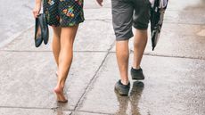 Why walking barefoot is good for you, Couple on the street under the rain, woman walking barefoot