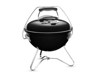 Weber Smokey Joe cooking small pieces of meat in black