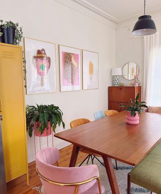A brown dining table with colorful chairs next to it and ice cream wall art on the wall