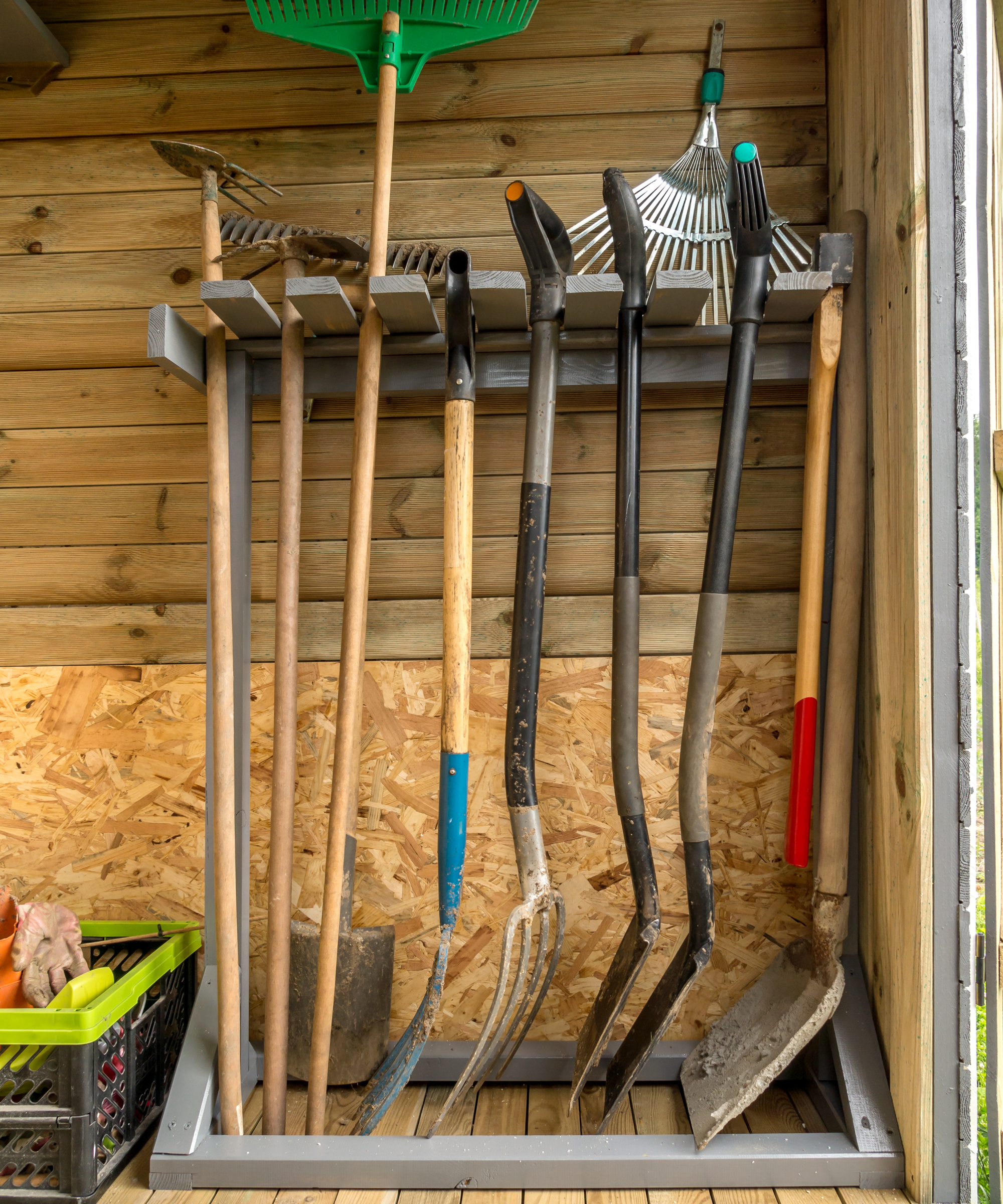 Gardening tools hanging in a DIY rack in a shed