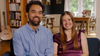 Catie and Josh smiling on the couch