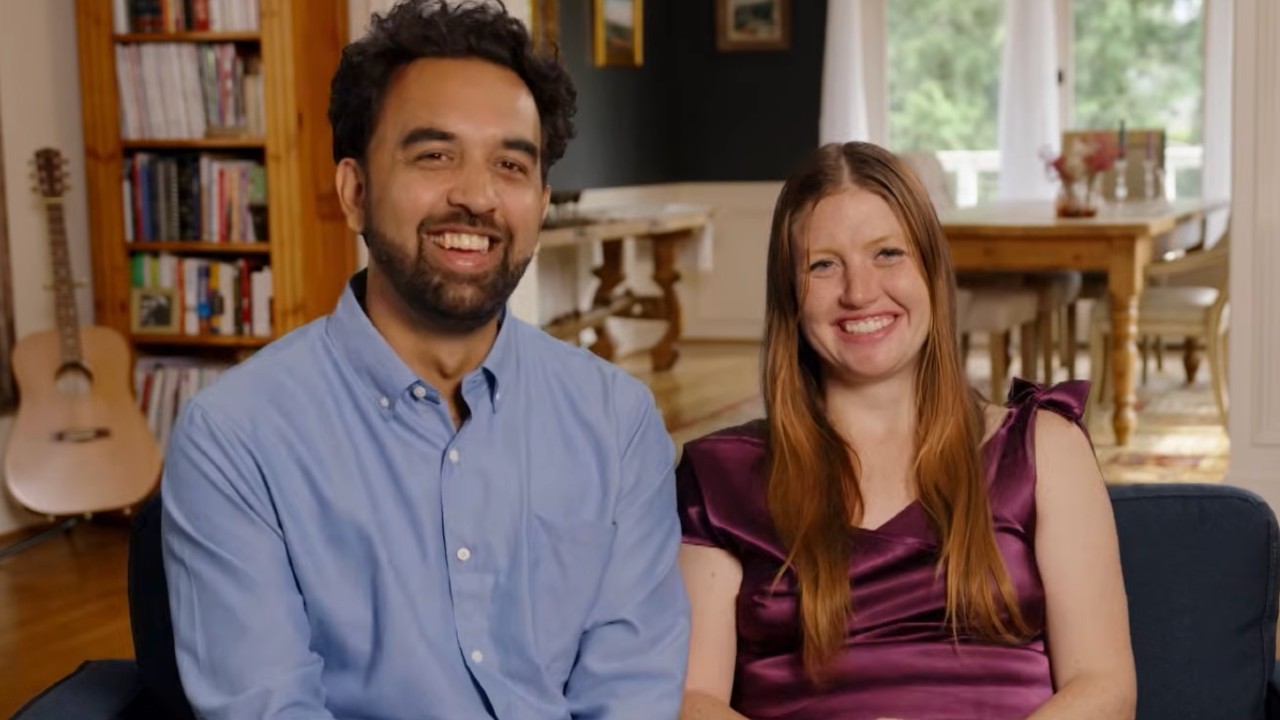 Catie and Josh smiling on the couch