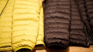 Close up of a black and a yellow down jacket next to each other
