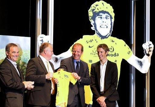 Andy Schleck, right, is presented with the yellow jersey from the 2010 Tour de France. On stage with Schleck are (l-r) five-time Tour champion Bernard Hinault, Luxembourg's sports minister Romain Schneider and Tour de France director Christian Prudhomme.