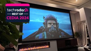 Home theater screen showing image of Top Gun: Maverick with Tom Cruise in plane and best of CEDIA 2024 awards badge