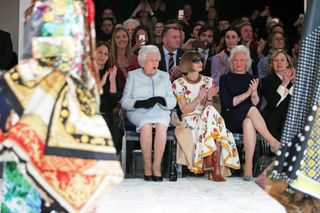 Queen Elizabeth II sits with Anna Wintour, Caroline Rush (L), chief executive of the British Fashion Council (BFC) and royal dressmaker Angela Kelly (R) as they view Richard Quinn's runway show before presenting him with the inaugural Queen Elizabeth II Award for British Design as she visits London Fashion Week's BFC Show Space on February 20, 2018 in London, United Kingdom.
