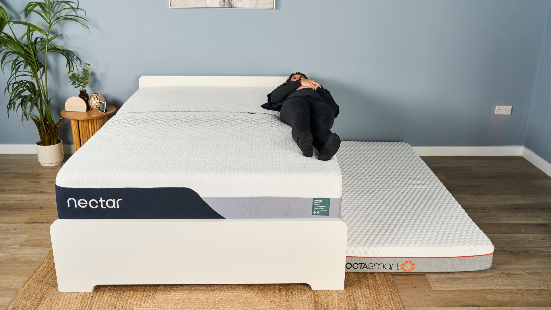 Sleep editor Lauren Jeffries rests right on the edge of the Nectar Premier Memory Foam Mattress. A thin mattress is positioned on the floor next to the bed, to cushion her if she should fall off the bed.