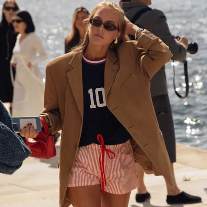 woman wearing a blazer, boxer shrts, a jersey, and a blazer in Copenhagen.