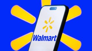 Walmart logo on smartphone against a blue background with yellow Walmart sprak