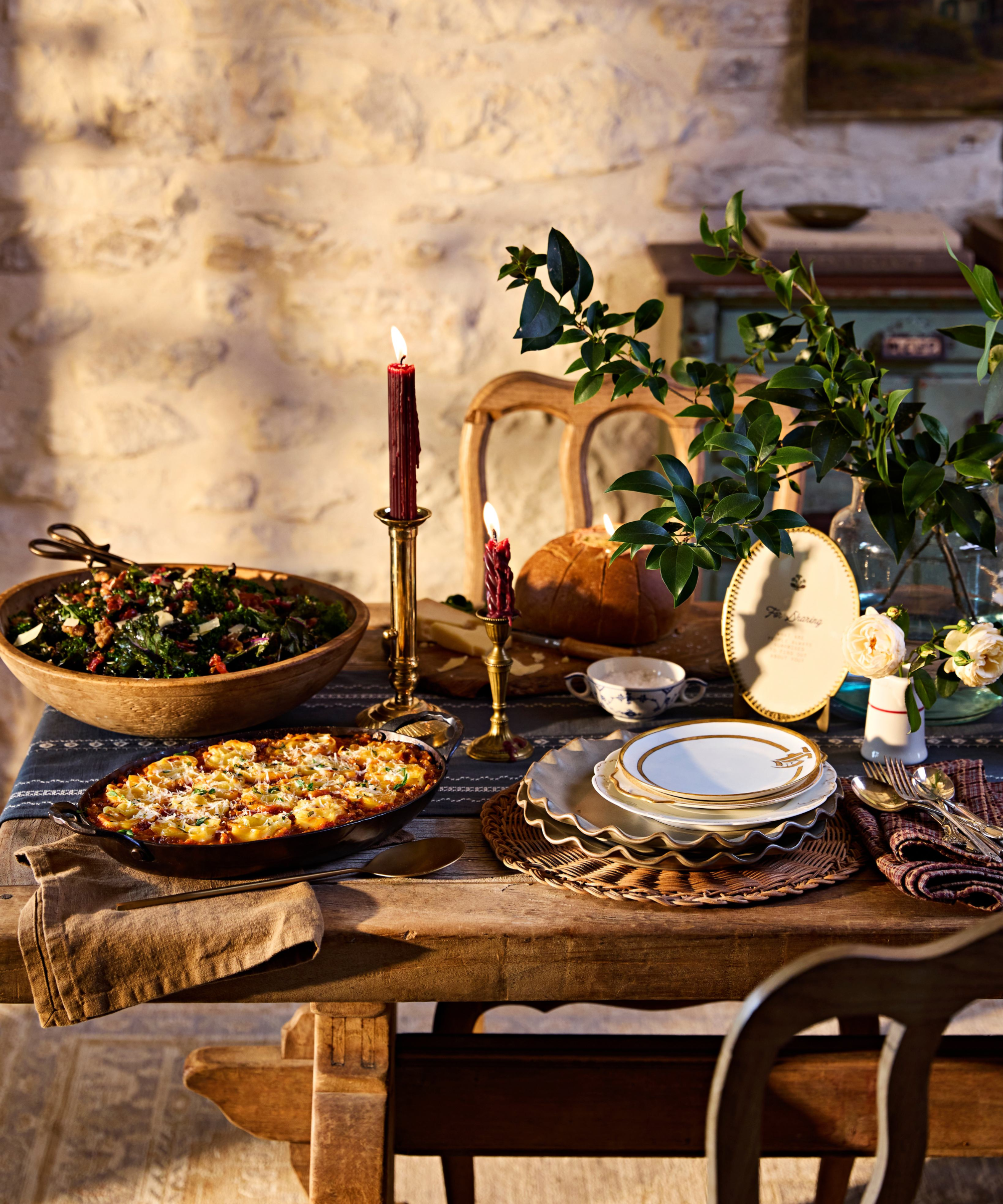 Layered, heirloom-inspired outdoor Thanksgiving tablescape featuring ruffled stoneware plates, woven chargers, and brass candlesticks from Magnolia's Thanksgiving 2026 collection