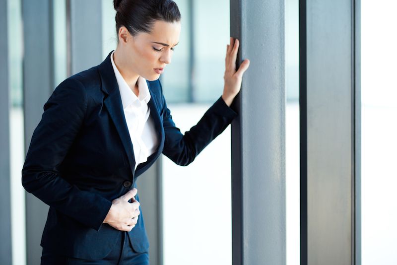 A woman experiences a stomach pain.