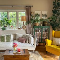 Country-style living room with white sofa and yellow chair and lots of cushions