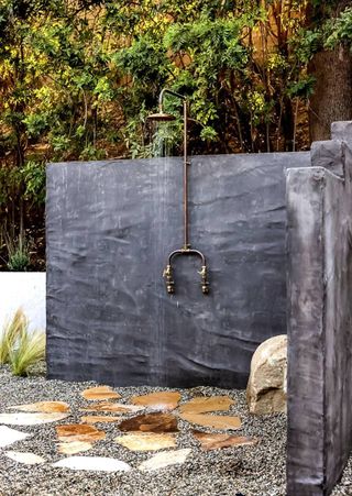 copper outdoor shower fixed to a stone wall