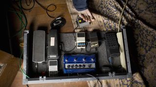 Man stomps his bare foot down on a guitar effects pedal