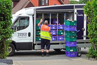 Tesco van driver loads onto trolley at customer home Essex England UK