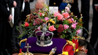 King Charles III walks alongside the coffin carrying Queen Elizabeth II with the Imperial State Crown resting on top