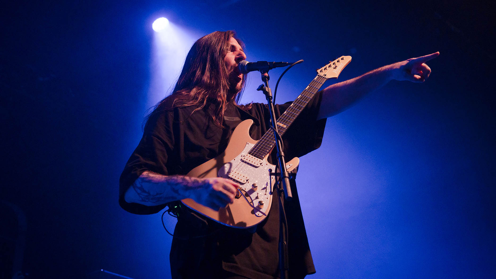 Scott LePage of Polyphia points the way during a 2024 live show.