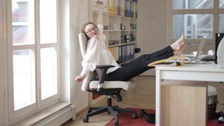 женщина отдыхает в белом офисном кресле