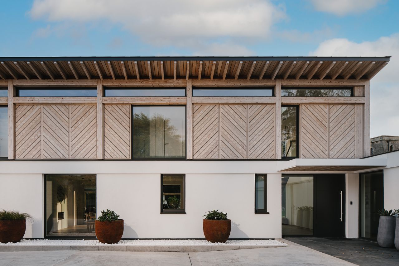 hero exterior of garden facade of timber clad sustainable hampshire home