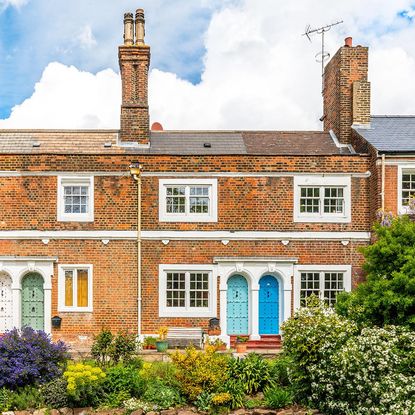 arched front door with garden and brick wall
