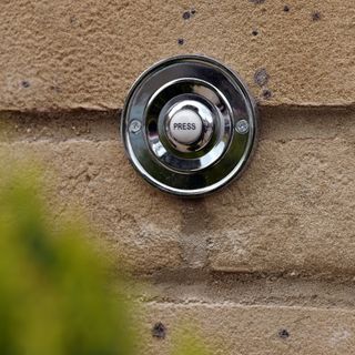 Silver doorbell with ring button on wall