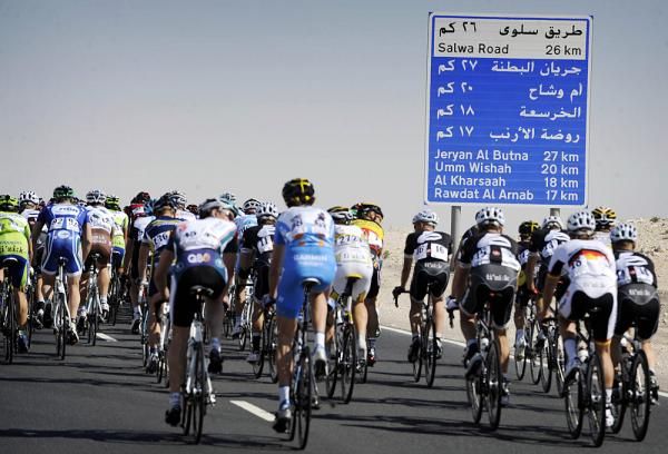 Riders speed down the barren, sandy flat.