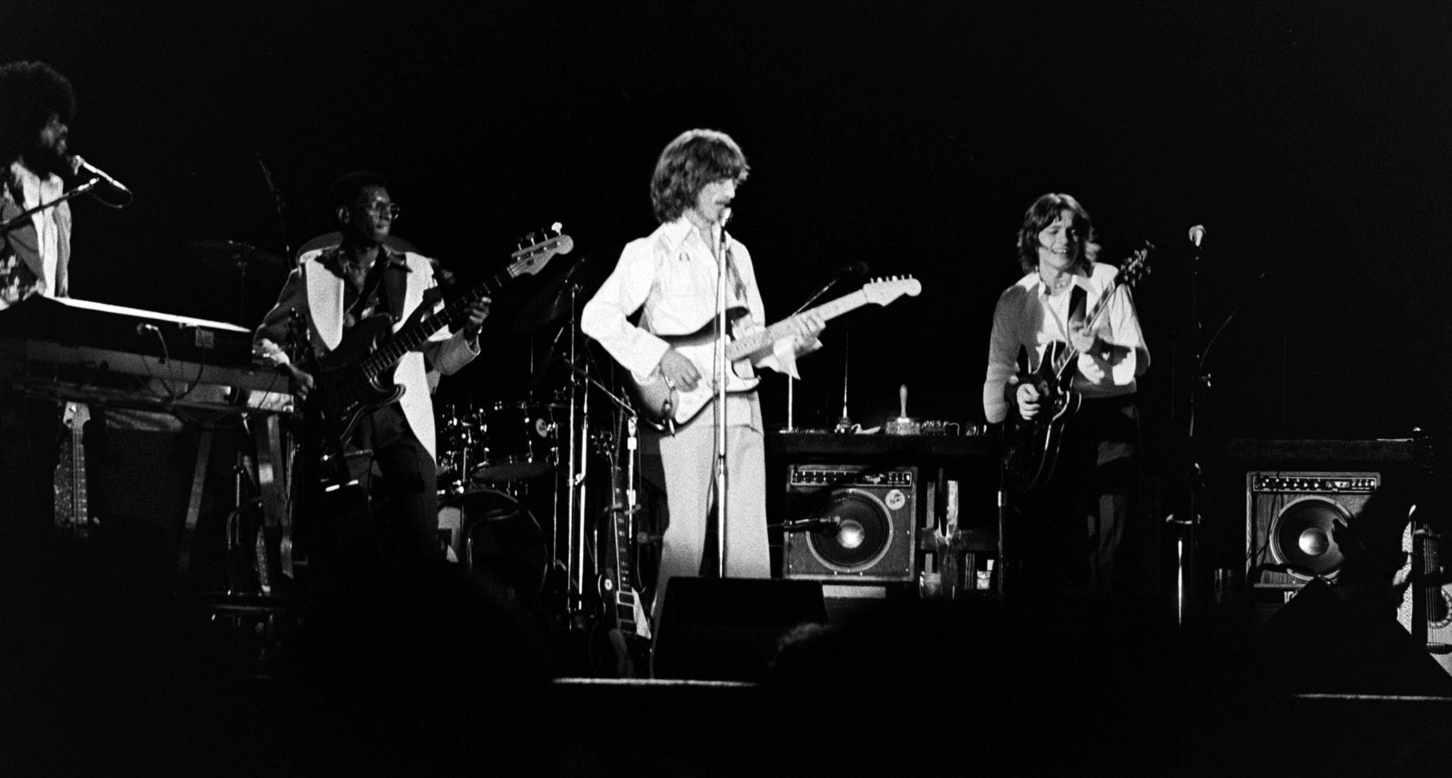 A black-and-white live shot of Robben Ford performing with George Harrison on the Dark Horse tour 1974.