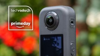 Akaso 360 camera close up of its front lens, with red flowers in the background