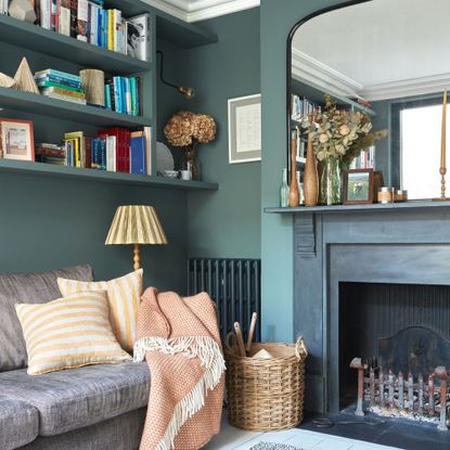Turquoise living room with grey sofa and large overmantle mirror