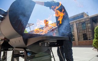 Best gas grills: A person works in front of a flaming BBQ grill