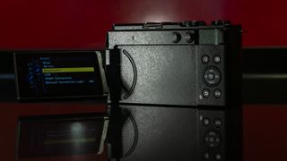 Appareil photo Panasonic Lumix S9 en couleur Olive foncé sur une surface rouge riche en reflets