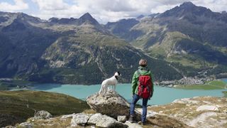 Woman hiking in mountains with her dog