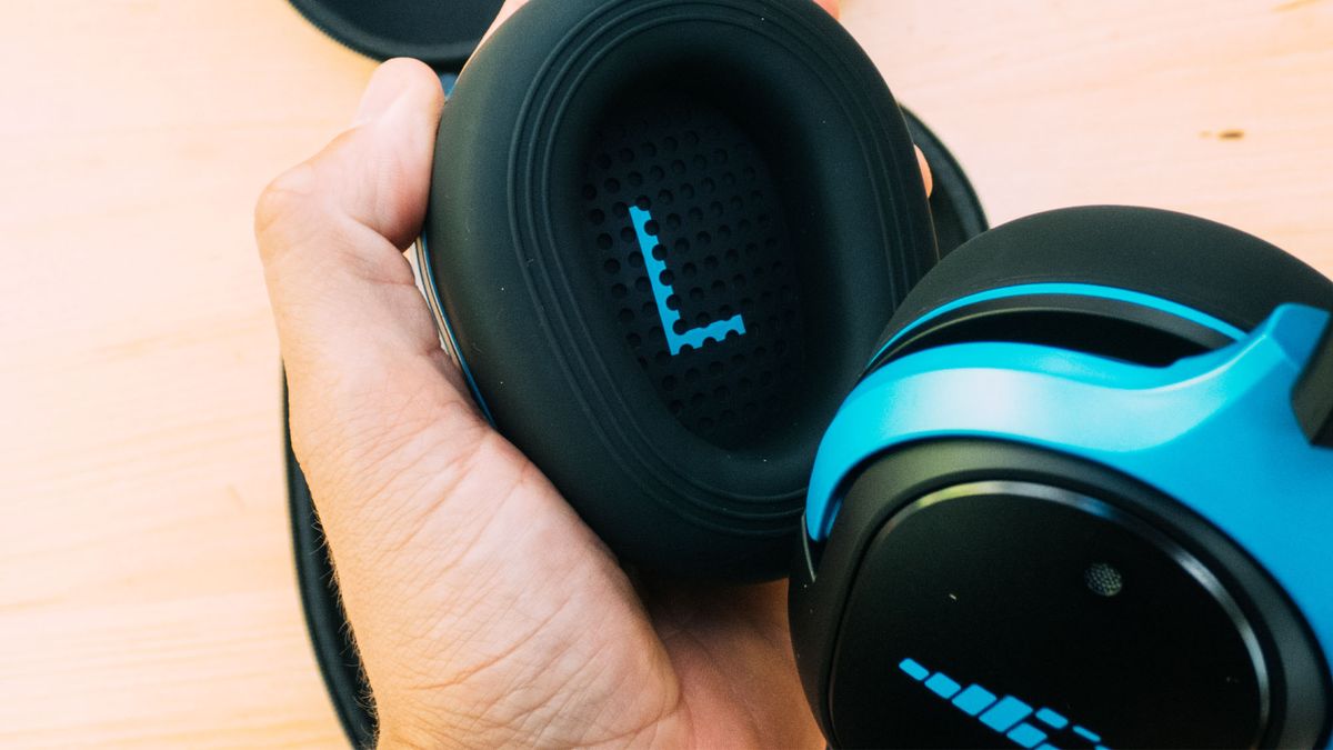 A pair of H2O Ript Ultra headphones being held in a hand