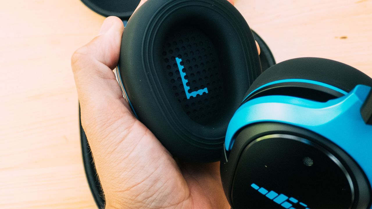 A pair of H2O Ript Ultra headphones being held in a hand