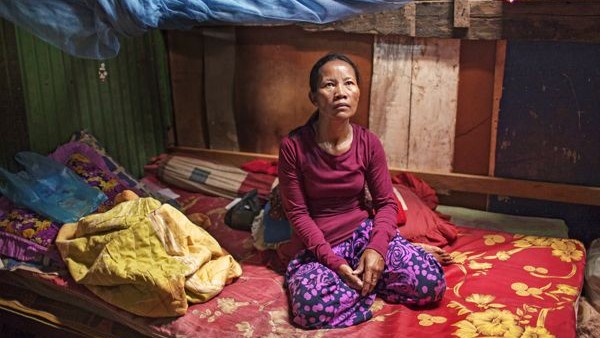 Cambodian woman sat on bed