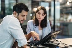 Two workers using AI on computer screen