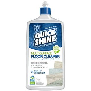 A gray plastic squeeze bottle of floor cleaner, with a blue cap and blue 'Quick Shine' label. 