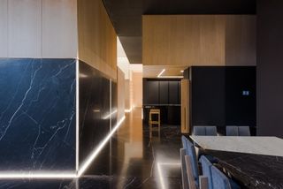 Llano Apartment corridor with marble and wood surfaces and low-level lighting