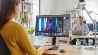 Best Photoshop plugins: a woman using Photoshop on a monitor screen
