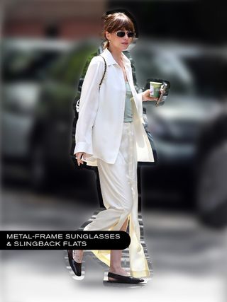 Dakota Johnson wearing a white shirt, white silk skirt, and black slingback flats.