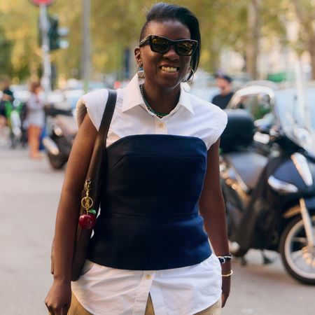 Nikki Ogunnaike wearing a white button down top, a blue corset, and khaki pants