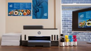 HP Smart Tank Printer with paper, ink, and business materials.