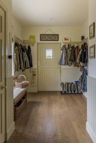 boot room with coat pegs and barn door