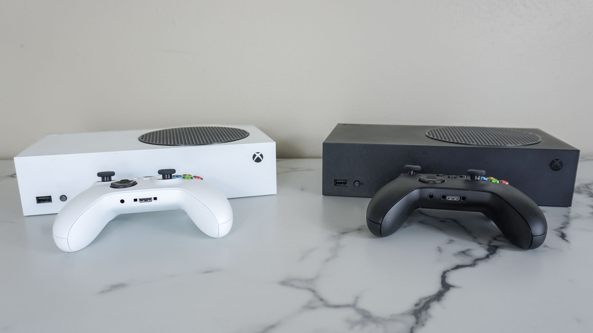 The white Xbox Series S next to the black Xbox Series S on a desk