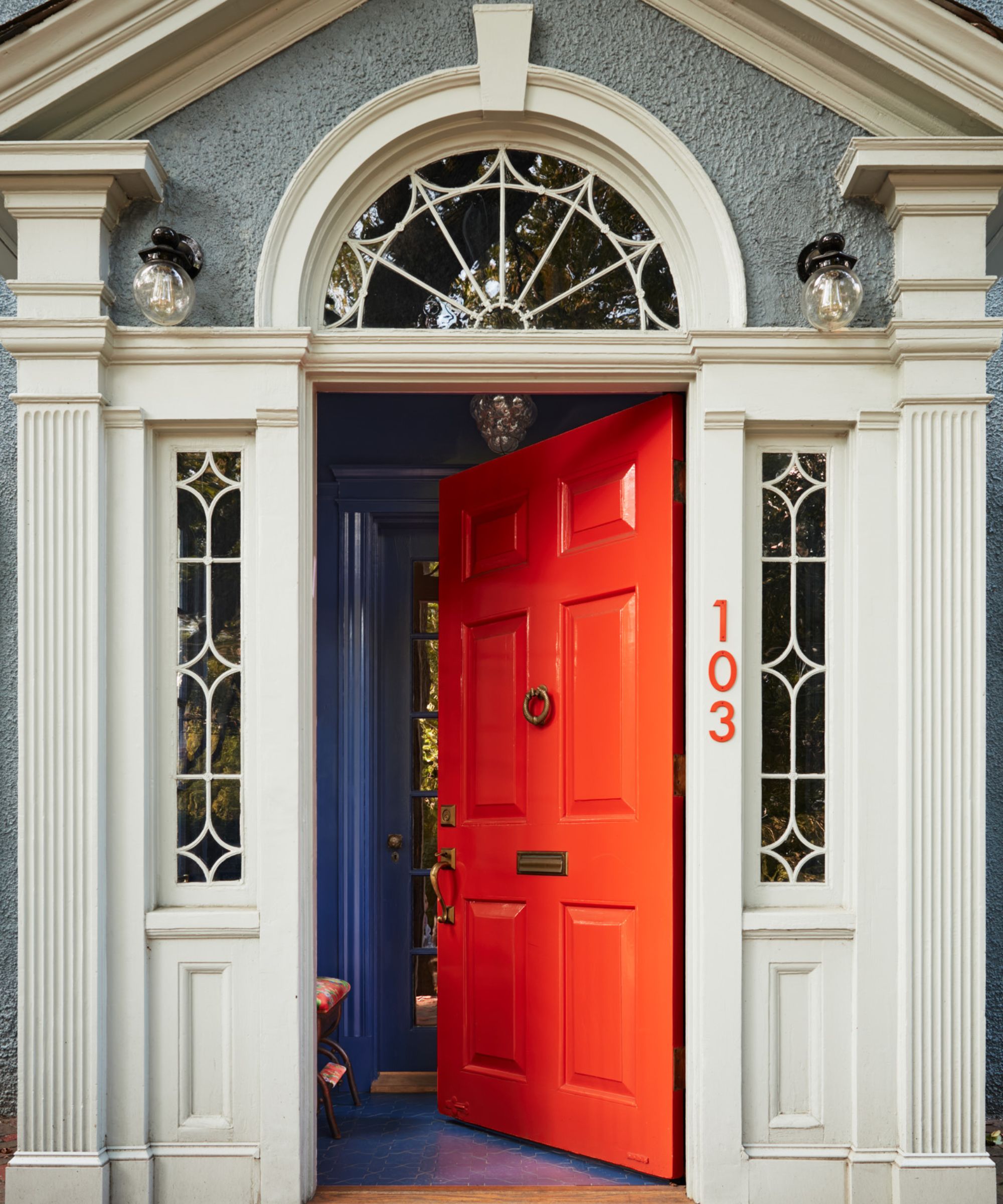 A home exterior with a bright orange-red front door.
