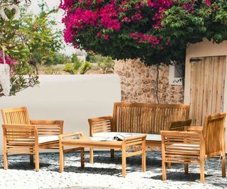 A wooden outdoor furniture set in a Mediterranean-inspired terrace